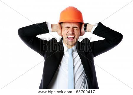 Businessman in helmet covering his ears over white background