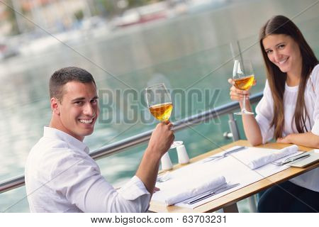 happy young couple having lanch at beautiful restaurant on by the sea on  beach