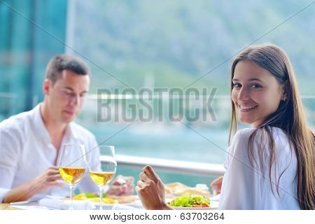 happy young couple having lanch at beautiful restaurant on by the sea on  beach