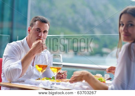 happy young couple having lanch at beautiful restaurant on by the sea on  beach