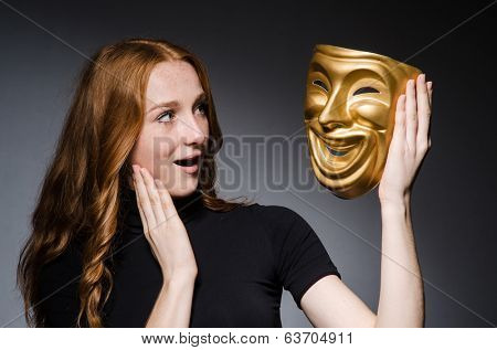 Redhead woman iwith mask in hypocrisy consept against grey background