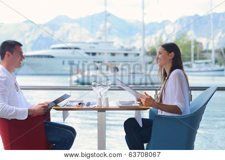 happy young couple having lanch at beautiful restaurant on by the sea on  beach