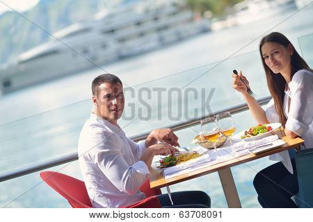 happy young couple having lanch at beautiful restaurant on by the sea on  beach
