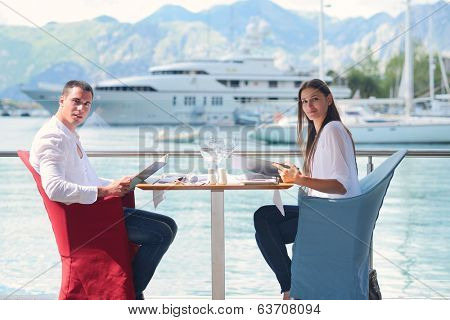 happy young couple having lanch at beautiful restaurant on by the sea on  beach
