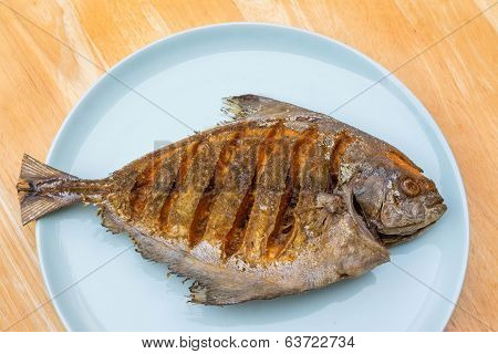 Asian Style Deep Fried Pomfret On Dish In Wooden Table Background