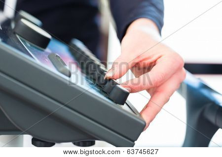 Female coach regulating intensity of ems electro muscular stimulation machine 