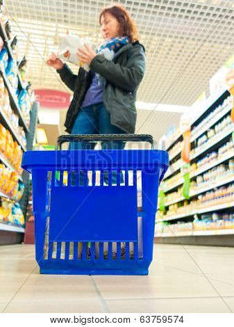 Woman Shopping With Blue Basket At Supermarket Shop. Retail.