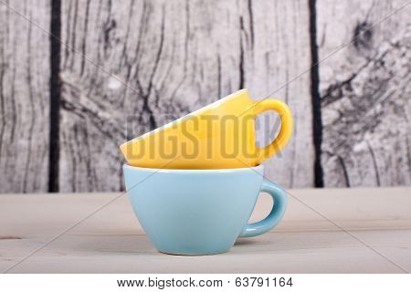 Cups On Table Over Wooden Background
