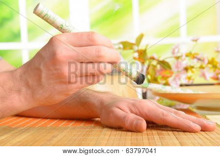 Professional moxa stick in hands of practitioner over patient body