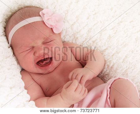 One week old newborn baby girl crying loudly. 