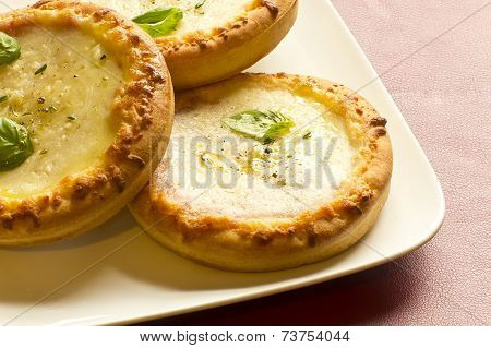 Pizzette mini Italian pizzas served with fresh basil leaves