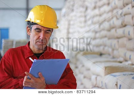Worker writing results in factory