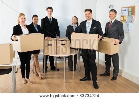 Employees In Office Holding Cardboard Boxes