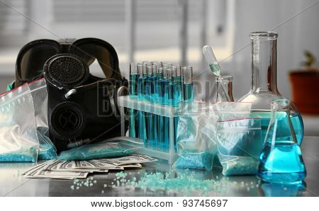 Drug laboratory: blue  methamphetamine and money on table close up