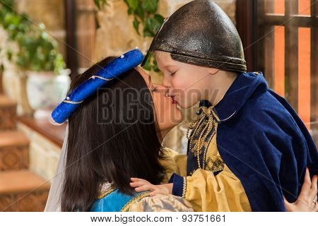 Mother and son in medieval costumes, in a beautiful interior.