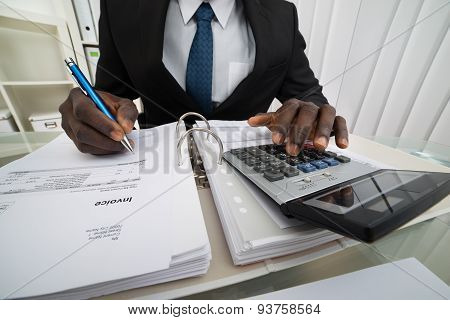 Businessman Calculating Invoices