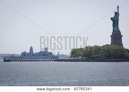 JERSEY CITY, NJ - MAY 26 2015: USS San Antonio (LPD 17) passes the Statue of Liberty on the Upper New York Bay after departing Pier 92 at the end of Fleet Week NY 2015.