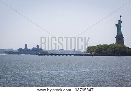 JERSEY CITY, NJ - MAY 26 2015: USS San Antonio (LPD 17) passes the Statue of Liberty on the Upper New York Bay after departing Pier 92 at the end of Fleet Week NY 2015.