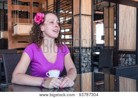 woman with a cup of coffee at a table in a restaurant