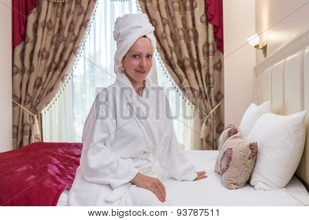 woman in a bathrobe with a towel on her head in a hotel room