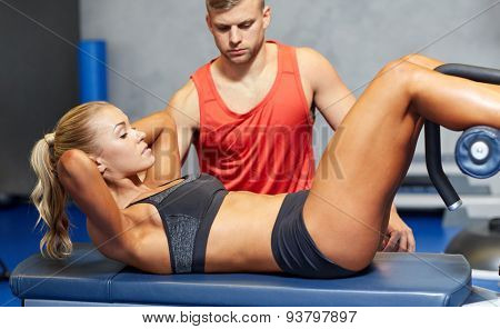 fitness, sport, training, gym and lifestyle concept - woman with personal trainer doing sit ups in gym
