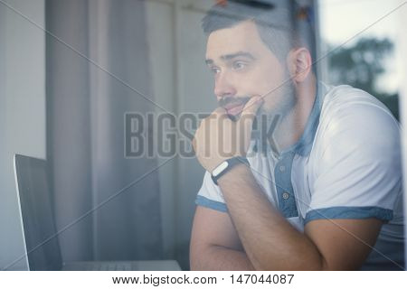 Thinking Man With Fitness Tracker In The Office Through Glass Window
