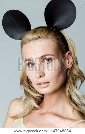 Blonde girl wearing bodysuit and black mouse ears