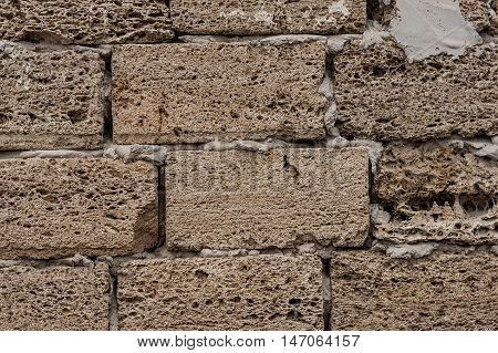 Background. The texture of the stone wall. Coquina material fastened with cement mortar.