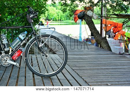 The Black bicycle on a wooden bridge in riverside.