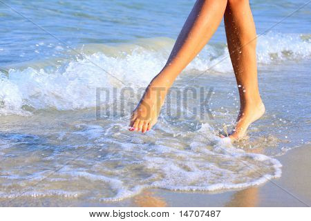 belle gambe di una bella ragazza camminare in acqua