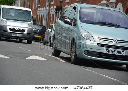 Traffic driving down street with speed bumps