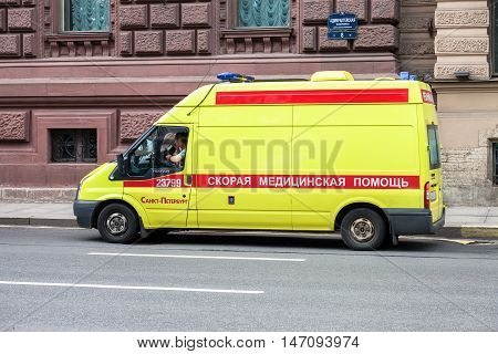ST. PETERSBURG RUSSIA - JULY 31 2016: Emergency ambulance car with blue flashing light on the roof parked up on the city street. Text in russian: " Ambulance" "Reanimation"