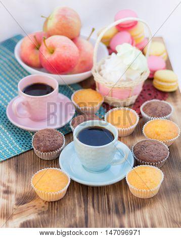 Still life of served coffee cups macaroon cookies marshmallows and apples