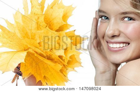beauty closeup portrait of attractive  caucasian smiling woman  isolated on white studio shot lips toothy smile face hair looking at camera teeth hand holding yellow marple autumn leaves