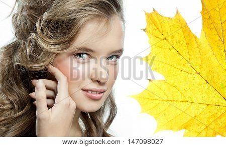 beauty closeup portrait of attractive  caucasian smiling woman  isolated on white studio shot lips toothy smile face hair looking at camera teeth hand holding yellow marple autumn leaves