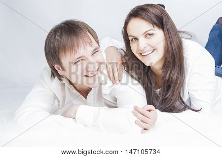 Portrait of Young Caucasian Family Lying on Floor Together Embrased.Horizontal Image