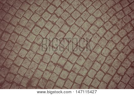 Background of old cobblestone pavement. Photo in brown tones.