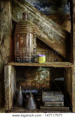 Shelf on old shed wall  with old bottle and old fashioned oil cans