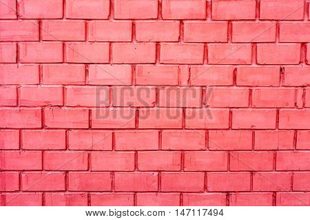 Brick wall made of bricks painted in pink. The texture of a brick wall. The horizontal masonry. Texture as background with a copy of the space.