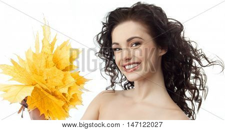 portrait of attractive  caucasian smiling woman brunette isolated on white studio shot hand holding yellow marple autumn leaves