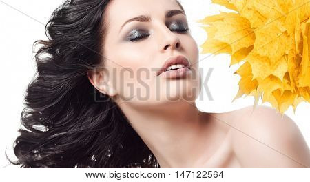 closeup beauty portrait of attractive caucasian woman brunette isolated on white studio shot lips  face hair head and shoulders eyes closed  yellow marple autumn leaves