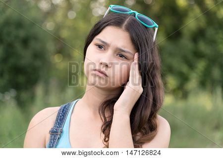 Portrait of a teen girl thinking about a problem on the nature