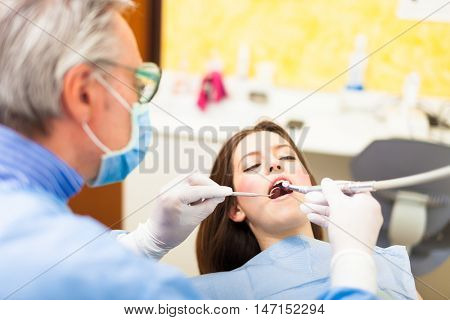 Dentist doing a dental treatment on a female patient