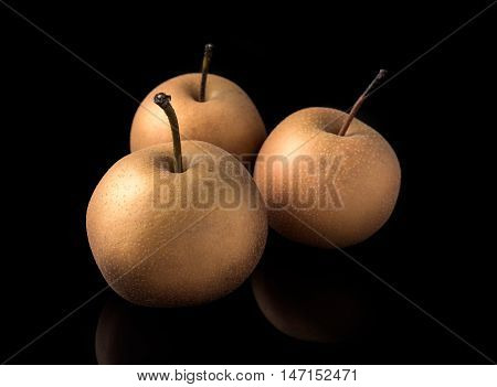 nashi japanese pears on dark board with reflections