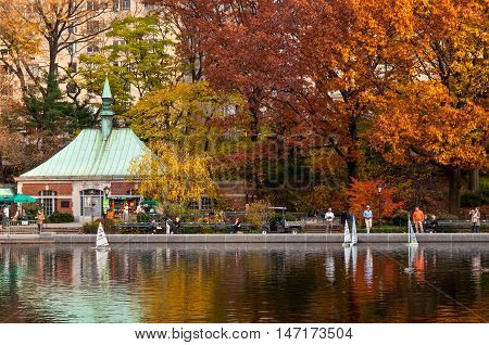 New York City USA - November 14 2011: A people sailing a model boats at the Conservatory Water in New York's Central Park at November 14 2011. Central Park's pond is popular with tourists who rent radio-controlled sailboats one lever on the controls turni
