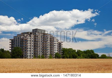 Modern residential high rise building in the middle of grain field landscape view