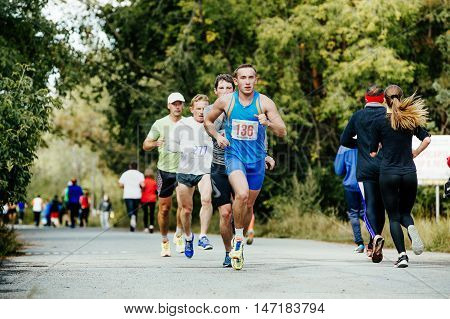 Chelyabinsk Russia - September 11 2016: young male runner leads a group of athletes running in Park during City marathon