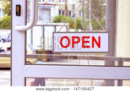 A sign with red letters on the front door