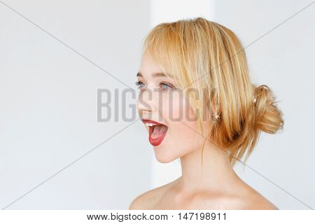 Adorable red-haired woman shouts with opened mouth. Impressed carroty girl feeling delight, free space