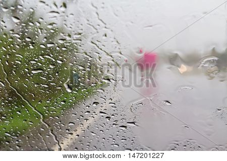 Road view through car windshield with rain drops Driving in rain.